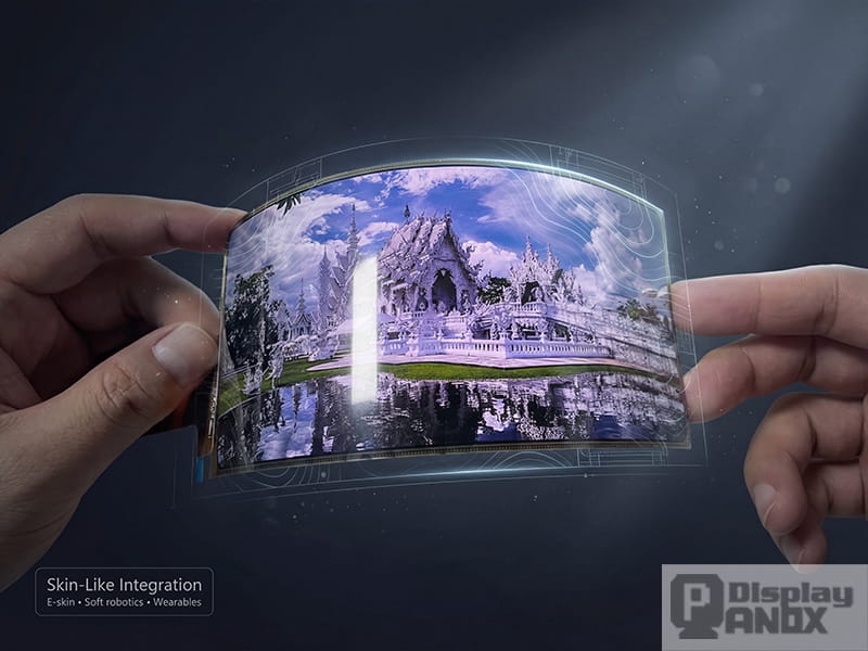 Hands holding a curved flexible OLED display module with subtle holographic overlays, illustrating skin-like integration for e-skin, soft robotics, and next-gen wearables.